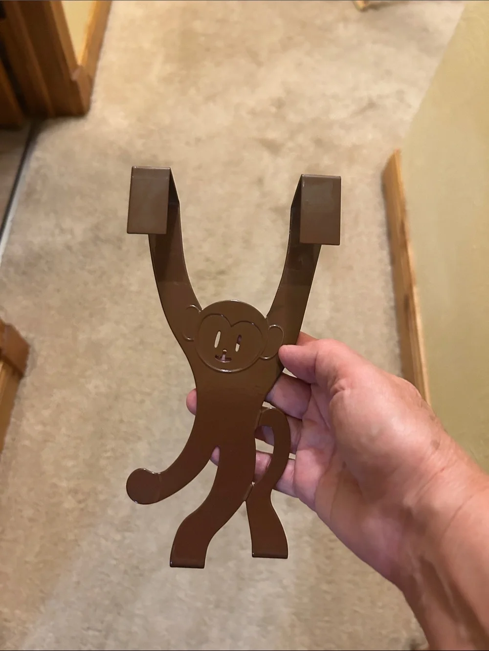 A set of 3 whimsical brown metal monkey over-the-door hooks